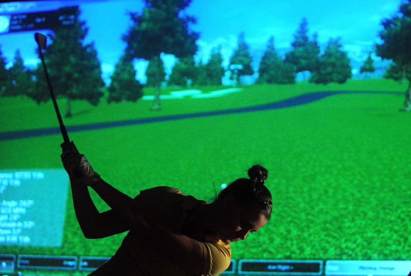 Ashley Chubbuck, 17, of Windsor, takes a shot during a round of virtual golf at the Alfond Youth Center on North Street in Waterville on Tuesday. The center's virtual golf program offers 26 courses, along with a driving range and two par-3 holes. Virtual golf is open to the public Tuesday and Thursdays, from 10 a.m. to 2 p.m., and 6 p.m. to 9 p.m.