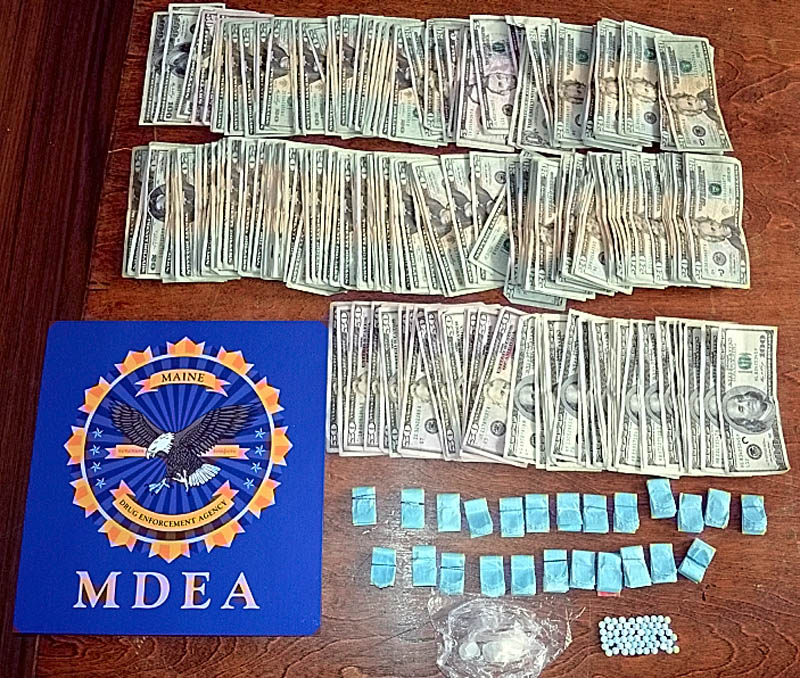 A photograph, contributed by the Maine Drug Enforcement Agency, shows cash, heroin, crack cocaine and pills seized during recent raids in Rangeley.
