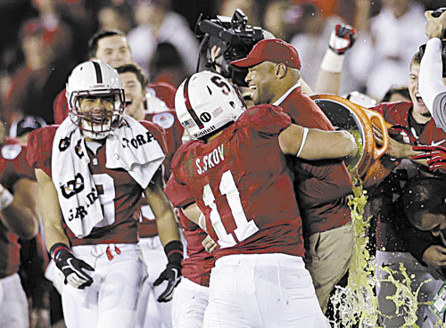 NICE WIN: Stanford head coach David Shaw is hugged by linebacker Shayne Skov (11) as he is doused following the Cardinal’s 20-14 win over Wisconsin in the Rose Bowl on Tuesday in Pasadena, Calif.
