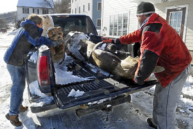 Don Bilodeau, left, moves a carved bear to make room for a life-sized sculpture of a person on Thursday. Bilodeau and artist Dan Burns were moving the sculpture from where it had been on display in Hallowell. Burns makes and sells chain saw sculptures outside McKenzie's Power Equipment on Route 17 in Augusta.