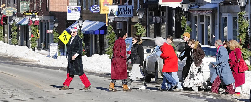 About 20 people dressed in pajamas and bathrobes or coats cross Water Street in downtown Hallowell on their way from an apartment, where they gathered on their way to a New Year's Day brunch at Slates Restaurant, on Tuesday. One of the organizers said that pajamas for brunch has been a holiday tradition for them for at least 10 years.