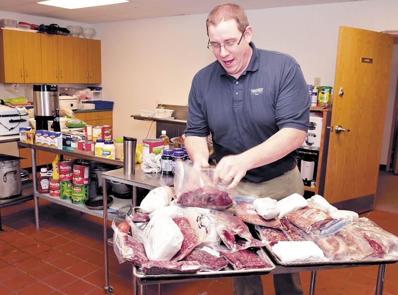 Aaron Hughes, head chef for the game dinner being held Friday at the Church of the Nazarene in East Madison, sorts through packages of elk, bear, venison, partridge and boar that will be served.