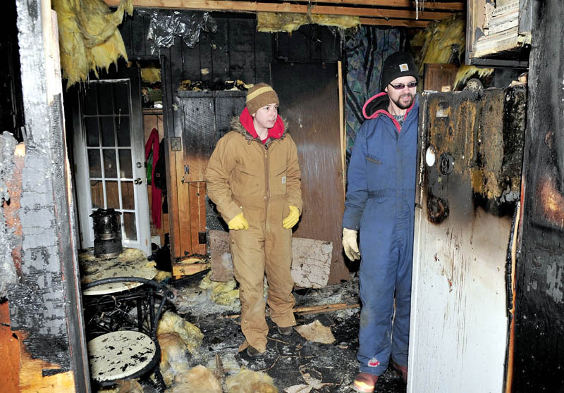 Kim Ricciardelli, left, and Bryan Cocchio search for salvageable photos inside the kitchen of their mobile home on Thursday. Fire destroyed the uninsured home Wednesday evening. Cocchio believes the fire may have started near some heat tape.