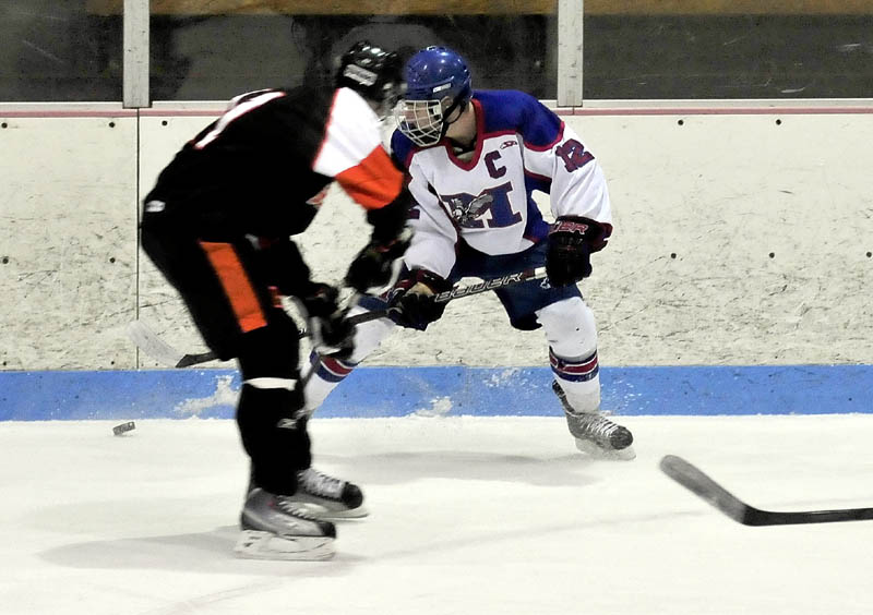 CHASE IT DOWN: Messalonskee’s Chase Cunningham (12) battles for the puck against Brewer on Wednesday at Sukee Arena in Winslow.
