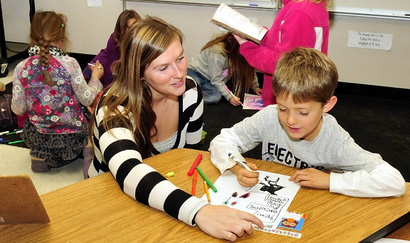Cornville Regional Charter School teacher Danielle Beaman helps student Barret Walker recently. The school is accepting applications for 28 new student slots, and will accept those students via a lottery.