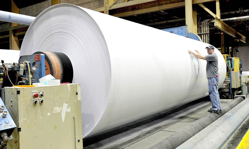 Sappi Fine paper worker Jeff Lancaster works on a huge roll of coated paper that will be cut into smaller rolls at the Skowhegan mill on Thursday.
