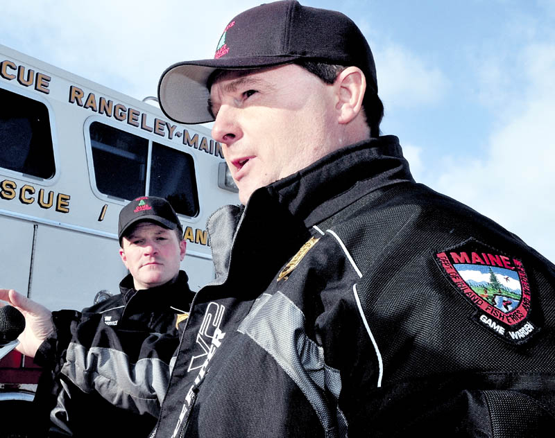 Maine Warden Service Lt. Kevin Adam, right, comments Tuesday about the ongoing efforts to recover the bodies of three snowmobilers who went through the ice Sunday on Rangeley Lake in Rangeley. The body of a fourth victim was recovered earlier. “I’ve been a game warden for 21 years. I can’t think of another incident where four people went in to the same body of water in one night,” Adam said.
