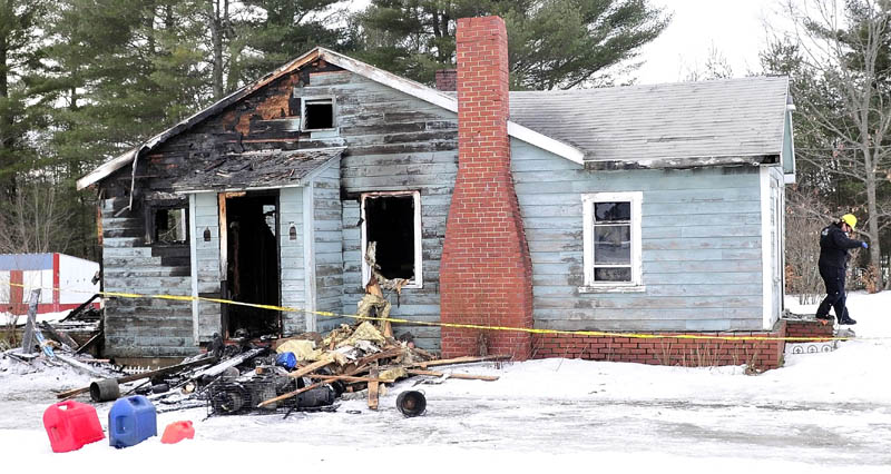 Mary MacMaster, an investigator with the State Fire Marshal's Office, exits the burned home of Al and Jenny Morales in Madison on Tuesday. Fire destroyed the home Monday evening.