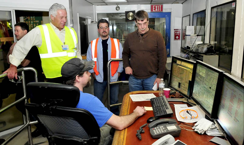 U.S. Rep. Mike Michaud, left, listens to Jeremy Vigue, seated in a paper machine control room, at the Madison Paper Industries mill, during a tour on Monday. Standing are, from left, employee Troy Bonnevie, Michaud, and employees Mike Croteau and Craig Hunnewell.