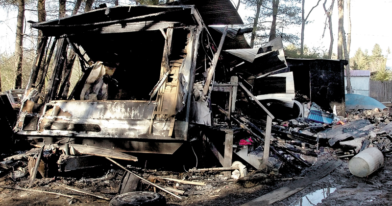 The charred remains of a mobile home where Robert and Kelley Robinson and their children escaped after fire quickly took over Tuesday on Smithfield Road in Norridgewock. Fire also damaged another home in town earlier Tuesday.