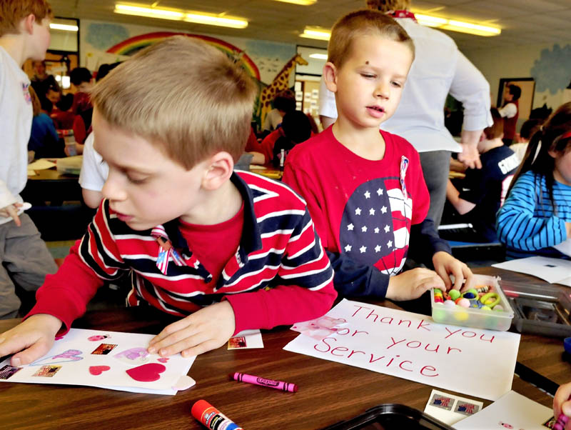St. John Catholic School students Parker Hunter, left, and Aidan Veilleux work on Valentines for Veterans at the Winslow school on Thursday.