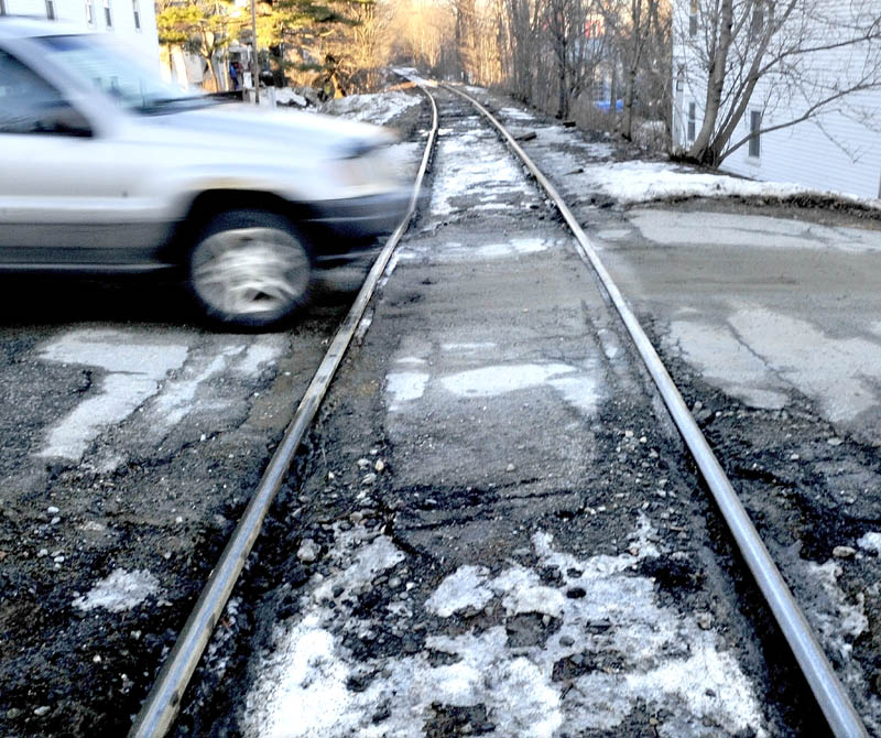 A motorist drives over a rough railroad crossing on Elm Street in Fairfield on Monday. The Town Council is considering closing the crossing, and possibly another, to qualify for grant money which could be used to repair other crossings in town.