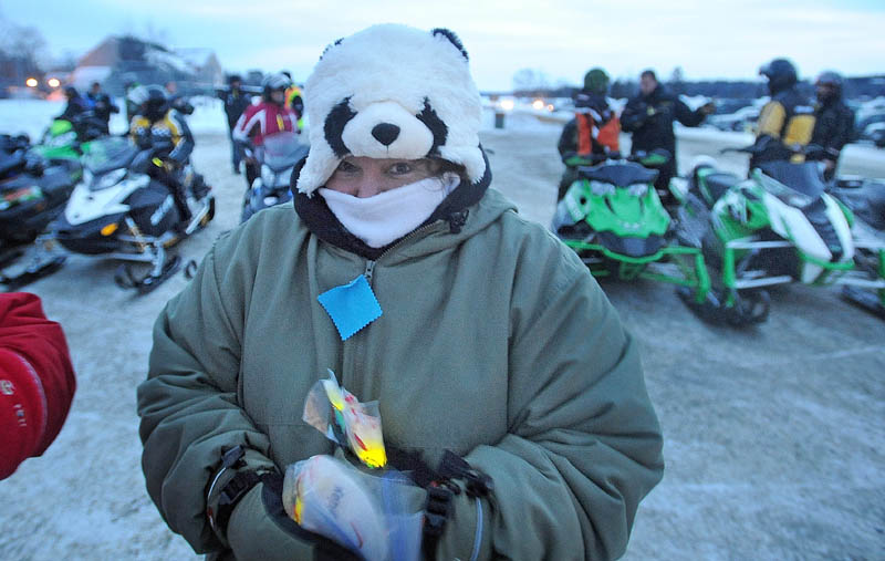 Leslie Walton hands out glow sticks before the Torch Light Snowmobile Safety Vigil in Rangeley on Friday night. The vigil was geared toward snowmobile safety awareness.