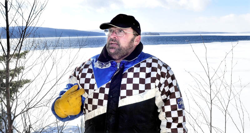 Rangeley resident Tim Lyons stands beside Rangeley Lake Tuesday near an expanding section of open water. Five years ago, Lyons' sled broke through the ice on Rangeley Lake, but he quickly scrambled out of the water. He was lucky, but it was a painful experience, he said.