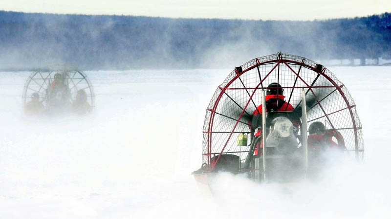 Two Maine Warden Service air boats head out on the ice on Rangeley Lake in Rangeley earlier this month to the open water location where four snowmobiles went through the ice on Dec. 30.
