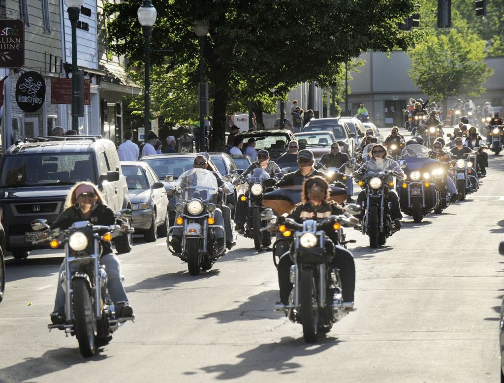 A motorcycle parade thunders down Water Street in Gardiner in this 2010 photo. Current law requires only motorcyclists under 18 years old to wear a helmet when driving or riding as a passenger.