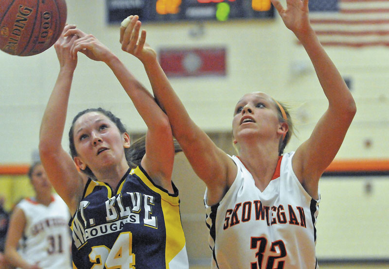 Mt. Blue High School's Amy Hilton, 24, left, and Skowhegan Area High School's Morgan Buker, 32, right, battle for the rebound in the first half in Skowhegan Friday..