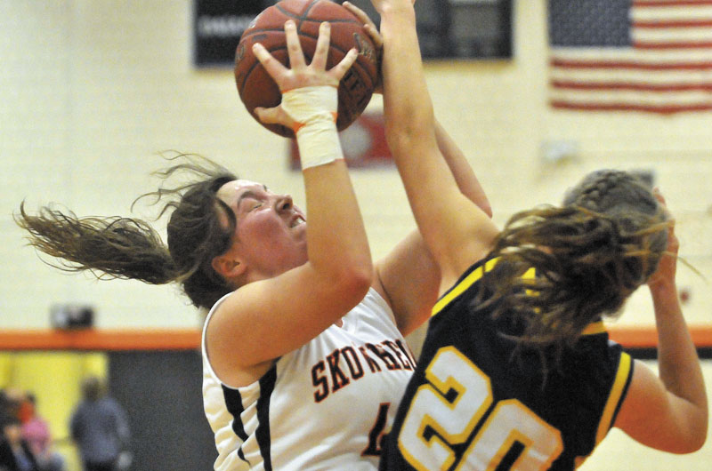 Skowhegan Area High School's Andrea Quirion, 44, left, battles for the rebound with Mt. Blue High School's Mackenzie Conlogue, 20, right, in the first half in Skowhegan Friday.