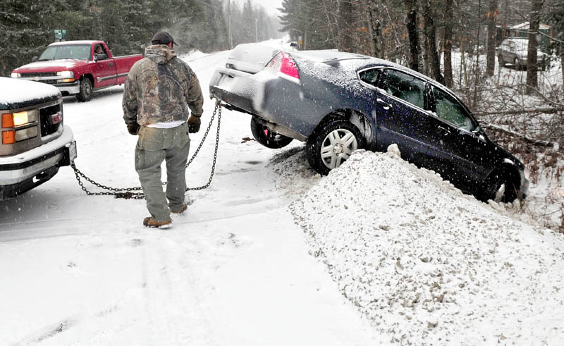 Todd Stanton backs up after attaching a chain to a vehicle that slid off Route 137 and landed in a snowbank on Hanscom Road in Benton on Wednesday.