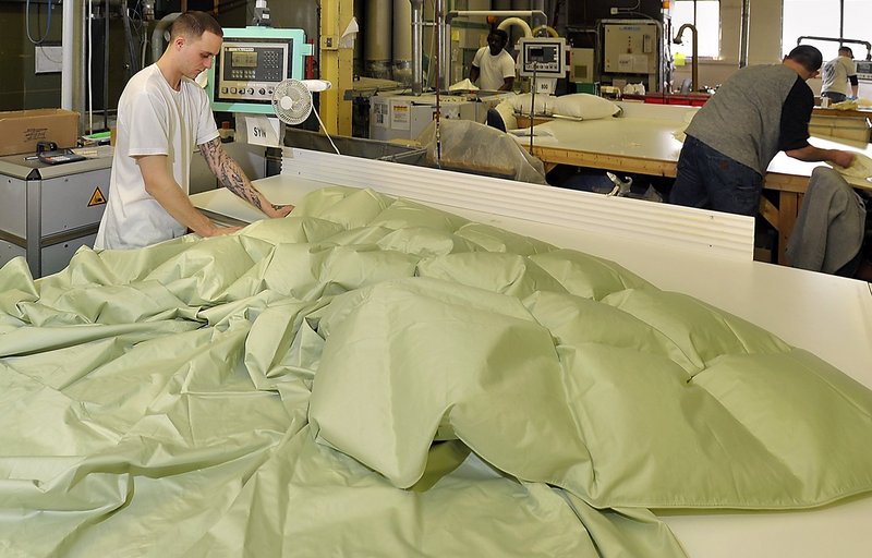 Bobby Hipsher fills a comforter with down in 2011 at the Cuddledown Inc. factory on Canco Road in Portland.