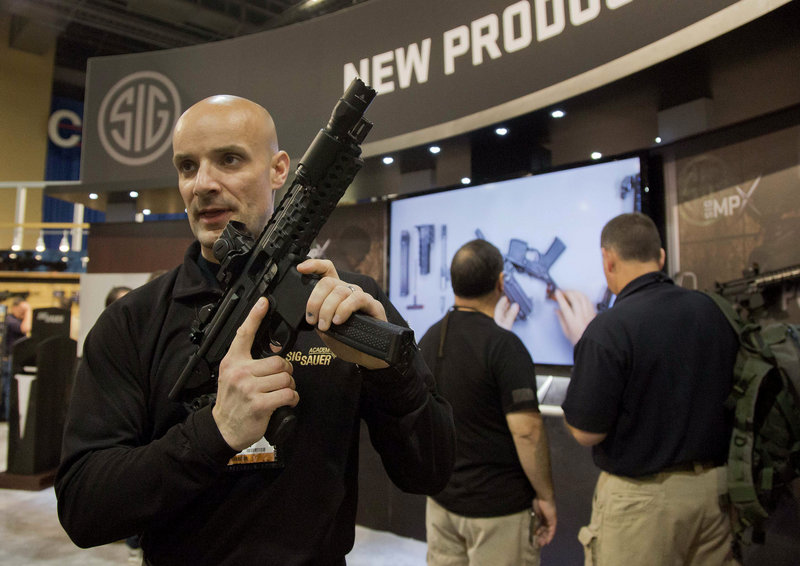 Adam Painchaud of Sig Sauer explains one of the company’s newest products, the MPX 9mm pistol caliber submachine gun, at the 35th annual “SHOT show” Tuesday in Las Vegas. The gun is for military and law enforcement use and not for sale to the public.
