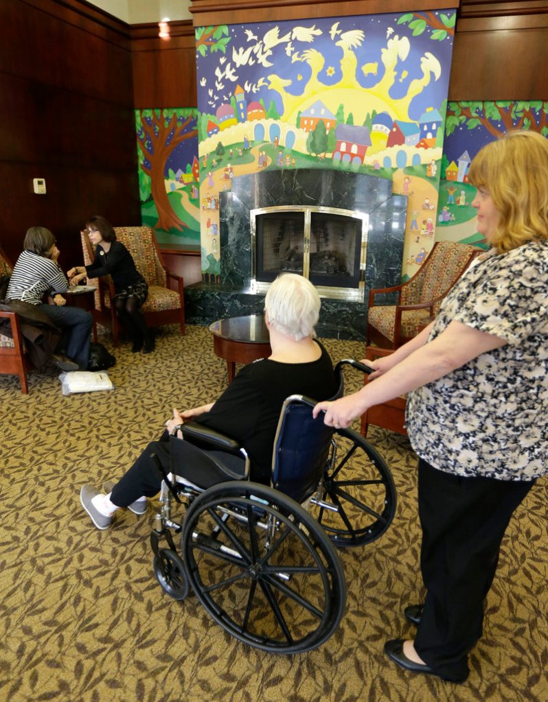 Caregiver Kim Bauer navigates an elderly woman’s wheelchair at the Cedar Village retirement community in Mason, Ohio. The woman, who is in her 70s, was allegedly abused by a relative. Cases of elder abuse typically go undetected, experts say, because the abuse – often by family members – is not reported due to embarrassment or fear.