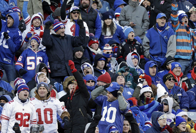 BUNDLE UP: New York Giants fans cheer during a game on Dec. 30, 2012 in East Rutherford, N.J. Just over a year before the New York area hosts the Super Bowl, the temperature was in the teens. With an outdoor game in a cold-weather state, the NFL will be at the mercy of Mother Nature for the 2014 championship.