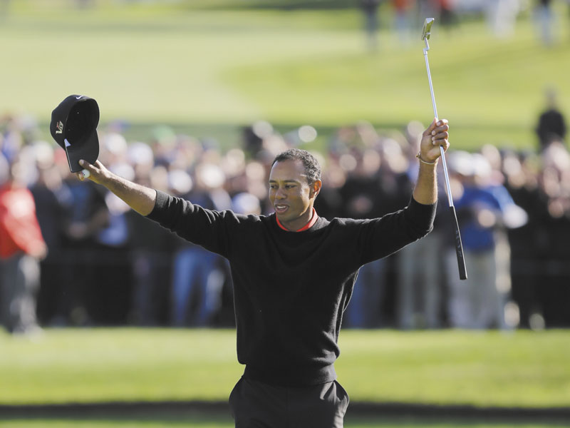 BACK ON TOP: Tiger Woods celebrates after winning the Farmers Insurance Open on Monday in San Diego. Woods closed with an even-par 72 for a four-shot victory.