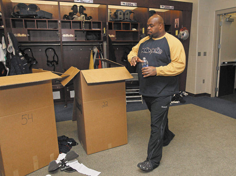 PACKING UP: New England Patriots defensive tackle Vince Wilfork walks past boxes of gear in the locker room Monday at Gillette Stadium in Foxborough, Mass. The Patriots wrap up their season after Sunday’s night’s loss to the Baltimore Ravens in the AFC Championship game.