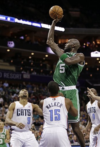 Boston Celtics' Kevin Garnett (5) shoots over Charlotte Bobcats' Kemba Walker (15) and Gerald Henderson (9) during the second half of an NBA basketball game in Charlotte, N.C., Monday, Feb. 11, 2013. The Bobcats won 94-91.