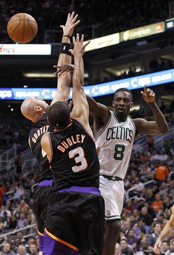Boston Celtics forward Jeff Green, right, passes the ball off as he is double-teamed by Phoenix Suns center Marcin Gortat, left, of Poland, and Jared Dudley, center, in the first half of an NBA basketball game Friday, Feb. 22, 2013, in Phoenix. The Celtics won 113-88.(AP Photo/Paul Connors)