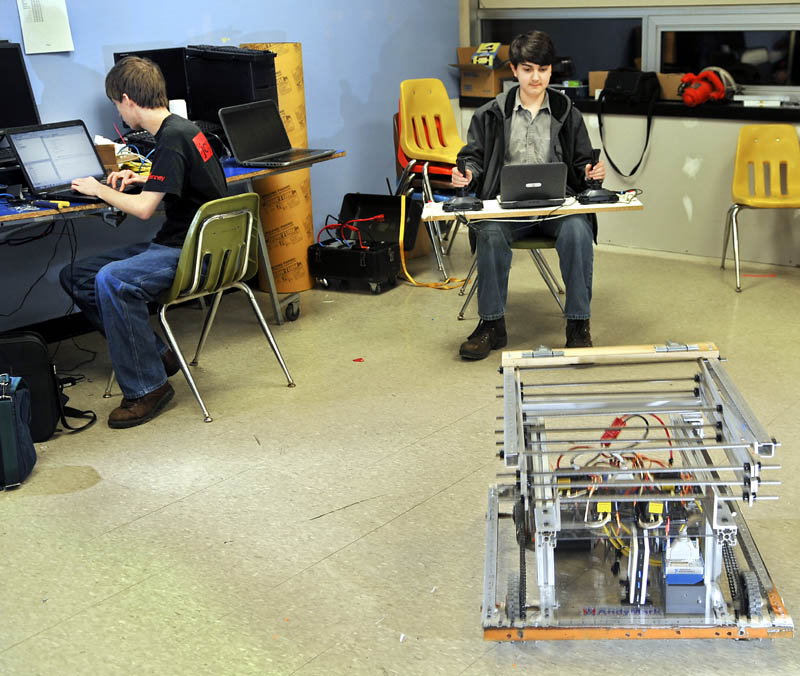 Gardiner Area High School robotics team member Ian Basford, right, steer his team's robot Thursday with dual joysticks, while teammate Harris Plaisted checks the code for the remotely operated machine on a computer.