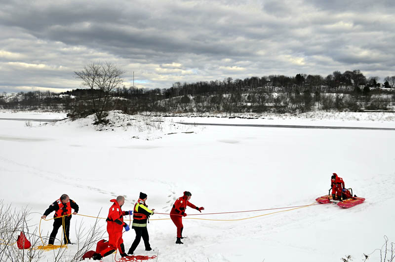 Augusta firefighters tow colleagues off the Kennebec River Tuesday in Augusta, during the department's annual ice rescue training. The firefighters practice retrieving either an injured or stranded person trapped on the ice with dry suits and a floating sled, according to Battalion Chief Scott Dunbar.