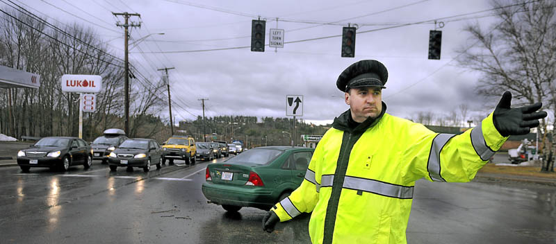 Augusta Police officer Paul Doody directs traffic at an intersection on Western Avenue Thursday following widespread power outages from high winds. Central Maine Power Co. reported about 400 customers in Somerset, Waldo, Lincoln and Sagadahoc counties remained without power at 6:55 p.m. Friday.
