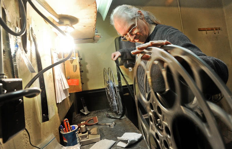Bill Lashon winds 35 mm film manually in the projection booth at the Pittsfield Community Theatre on Main Street Thursday. The movie industry is shifting from the 35 mm film to digital by the end of the year.