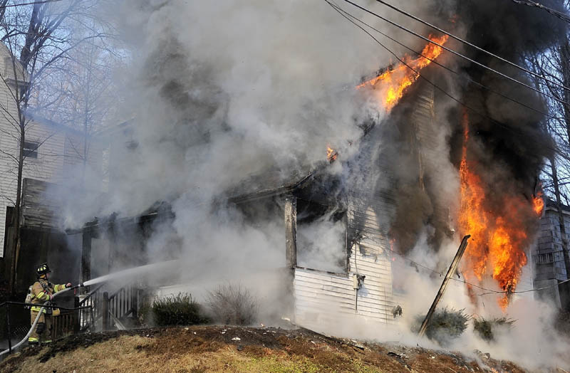Firefighters battle a blaze on Squire Street in Waterville Thursday.