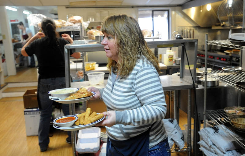 Shelly Stevens, former owner of Thompson's Restaurant, along with her husband, Parker, carries orders from the kitchen to patrons on Wednesday. Stevens still works as a waitress for the new owners of Thompson's Restaurant.