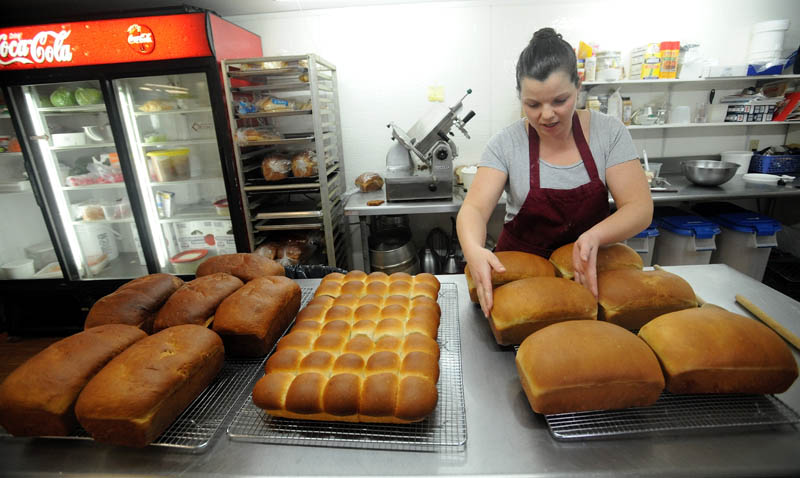 Heather Beane pulls some fresh-baked bread out of the oven, and places the loaves on cooling racks, at Thompson's Restaurant on Main Street in Bingham on Wednesday.