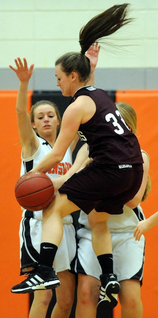 TURNOVER: Nokomis High School's Taylor Shaw (32) gets the ball stripped as Winslow High School's Erica Bertolaccini (5) and Morgan Clark (32) defend in the second quarter Tuesday in Winslow.