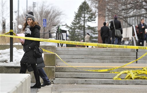 Pedestrians walk by police tape on the MIT Campus in Cambridge, Mass.,after police responded to reports of a gunman on campus on Saturday.