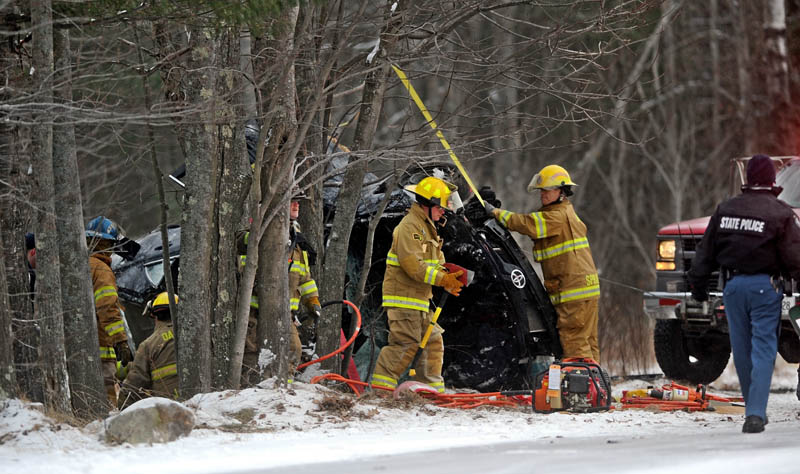 Rescue workers and firefighters extract a driver from a vehicle that lost control and rolled over into the woods on Route 8, near McGrath Pond Road in Belgrade, Friday afternoon.