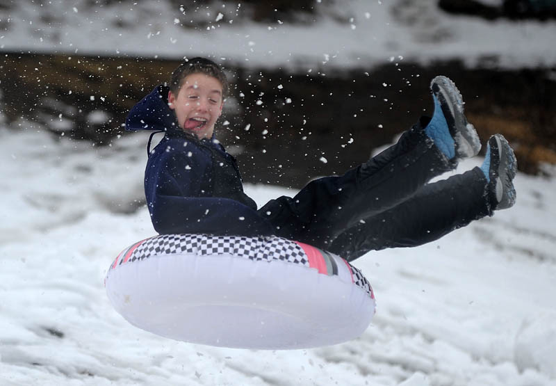 Anthony Visconti, 13, of Waterville, launches off a jump at the Sherwin Street hill in Waterville Wednesday. The storm closed schools early Wednesday affording area kids the opportunity to sled one more time on the icy hill before fresh snow slows down the descent.