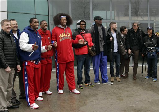 Flamboyant former NBA star Dennis Rodman, fifth from right, poses with three members of the Harlem Globetrotters basketball team, in red jerseys, and a media production crew upon arrival at Pyongyang Airport on Tuesday.