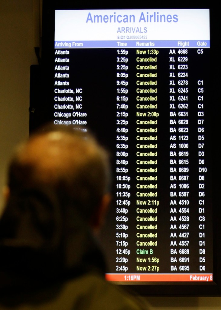 A patron checks to see if his flight is cancelled at LaGuardia Airport Friday, Feb. 8, 2013, in New York. Most airlines were giving up on flying in and out of New York, Boston and other airports in the American Northeast on Friday as a massive storm threatened to dump up to a meter of snow in some parts. (AP Photo/Frank Franklin II)