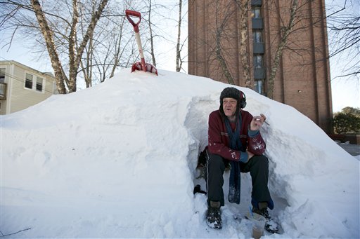 Bert Johnson takes a break while clearing snow from a bus stop bench outside the apartment complex where he lives in Portland, on Sunday. Residents were digging out after a blizzard dumped a record 31.9 inches of snow on the city.
