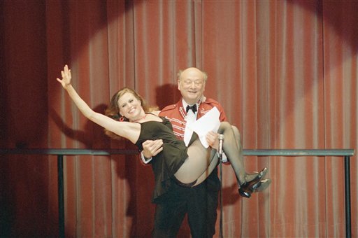 In this March 8, 1987, photo, New York Mayor Ed Koch gives a lift to Broadway dancer Ann Reinking during a performance of political satire on at the annual Inner Circle gathering of the New York Press Club in New York.