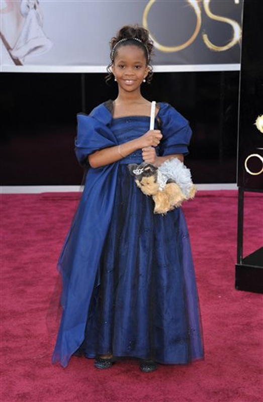 Quvenzhane Wallis wears an Armani Junior navy-blue dress with black, navy and silver jewels scattered on the skirt and a big bow on the back as she arrives for the Academy Awards.