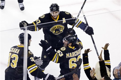 Boston Bruins left wing Brad Marchand (63) celebrates with defenseman Zdeno Chara (33) and center Patrice Bergeron (37) after his goal tied them with the New York Rangers near the end of the third period of an NHL hockey game in Boston, Tuesday, Feb. 12, 2013. (AP Photo/Elise Amendola)