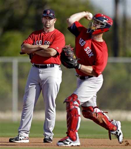 Former Boston Red Sox catcher and captain and now special assistant to the team, Jason Varitek, left, watches as catcher David Ross throws during a spring training baseball workout, Wednesday, Feb. 20, 2013, in Fort Myers, Fla. (AP Photo/David Goldman)
