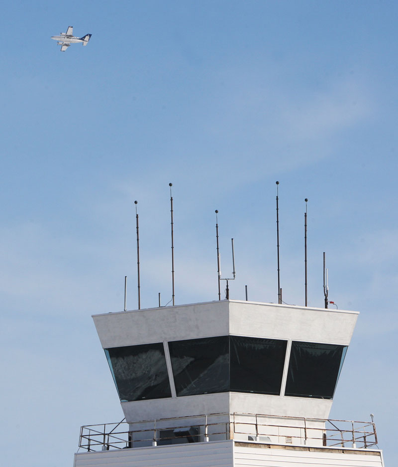 A twin engine airplane flies by the tower at St. Louis Regional Airport in Bethalto, Ill., Monday Feb. 25, 2013, before circling to land. The airport is one of 100 airports nationwide with less than 150,000 annual flights that will likely loose their air traffic control by the end of the week if a budget deal is not reached in Washington. The Federal Aviation Administration has notified the airport that it is on the list and that $600 million will be cut from the FAA's budget if sequestration cuts take effect on March 1. (AP Photo/The Telegraph, John Badman)